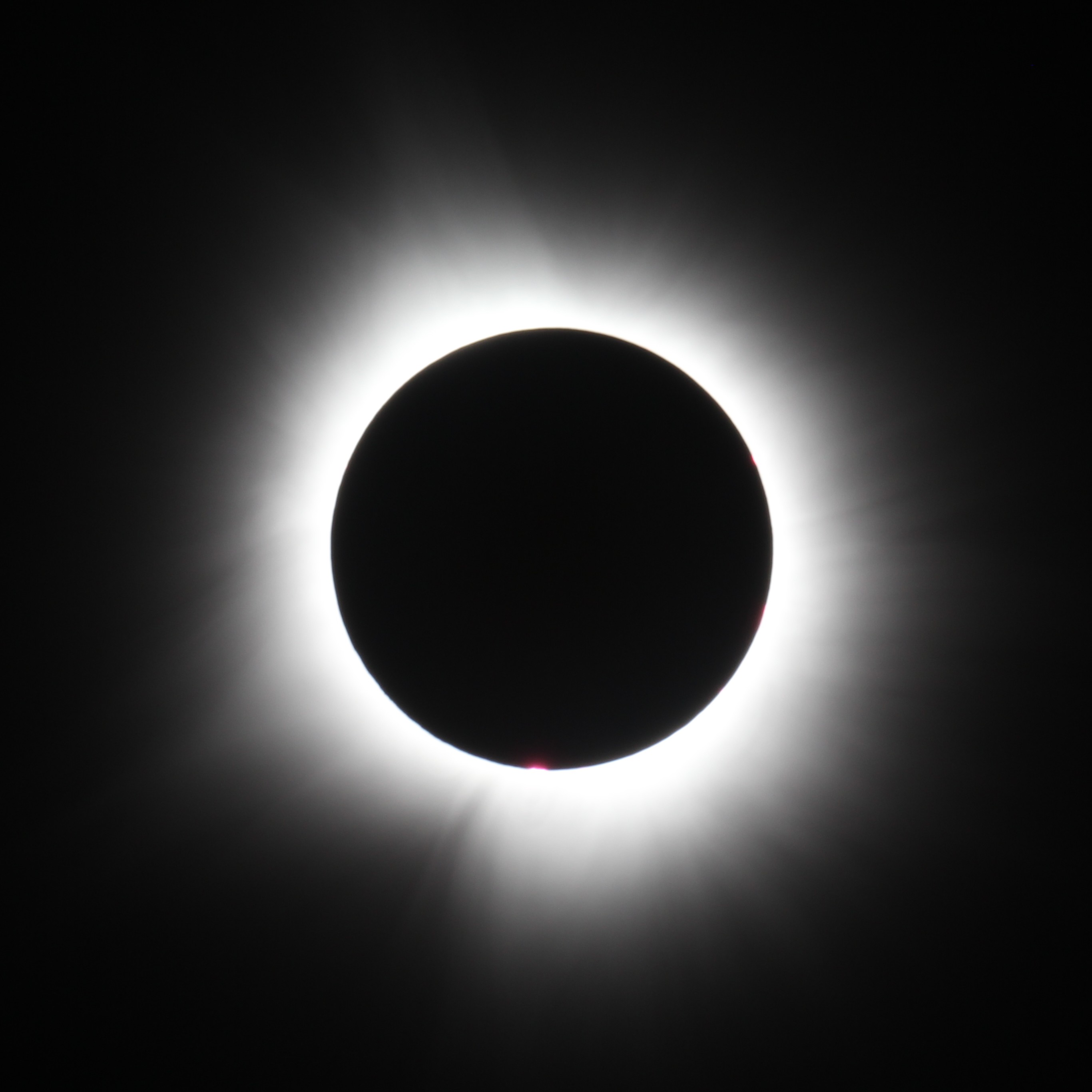 Eclipse solar total com a coroa do Sol brilhando ao redor da Lua